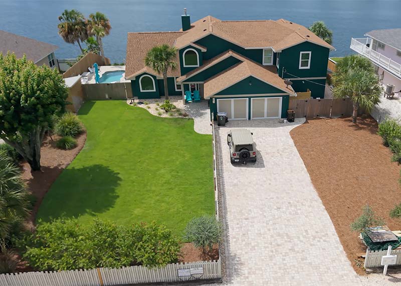 Arial image showing completed landscape design and Build project on custom paver driveway on the intercoastal