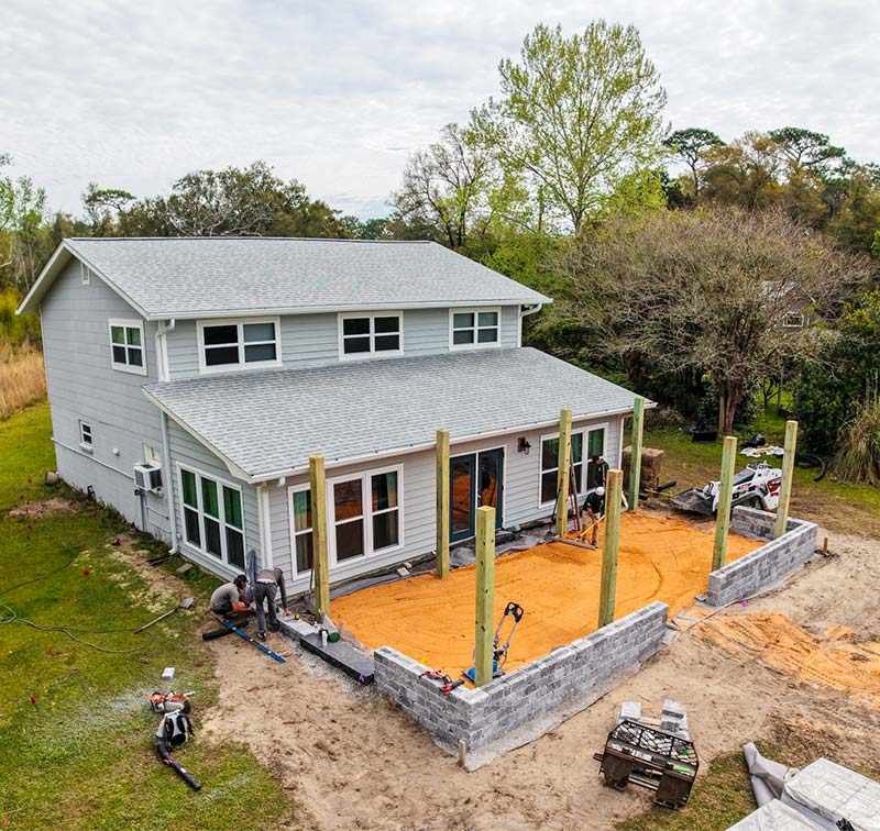 Drone image showing a design buid project with custom patio pavers and with ground prep work for drainage