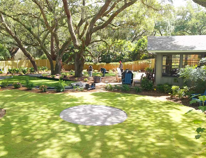 Outdoor living space with fire pit area and artificial turf and landscape design